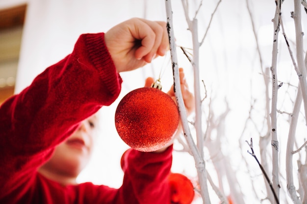 Vista de cerca de niña decorando árbol de navidad