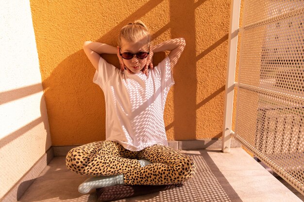 Vista de cerca de un niño encantador mirando a la cámara con gafas de sol naranjas