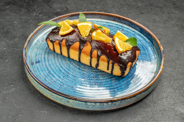 Vista de cerca de pastel suave decorado con naranja y chocolate en la mesa oscura