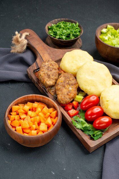 Vista de cerca de sabrosas chuletas verduras picadas en la oscuridad