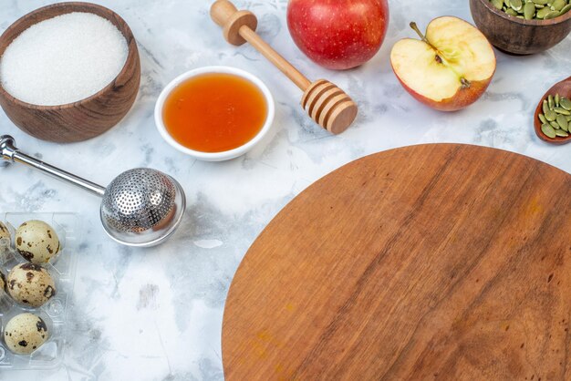 Vista de cerca del tablero redondo y los ingredientes para la comida saludable sobre fondo blanco manchado