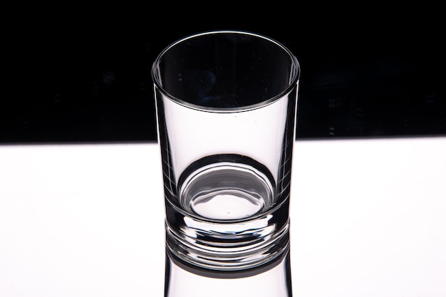 Vista de cerca de la taza de vidrio en la mesa blanca sobre fondo oscuro con espacio libre