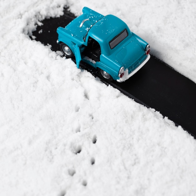 Vista cercana del coche de juguete azul con nieve