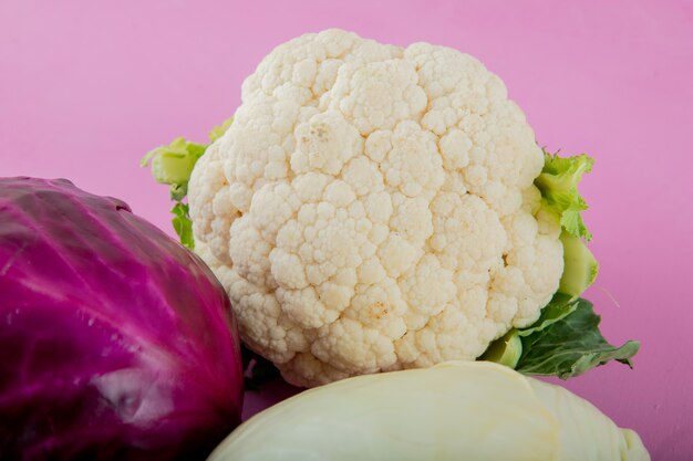 Vista cercana de coliflor con col morada sobre fondo morado