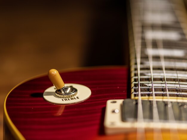 La vista cercana del cuerpo de la guitarra eléctrica está en el piso de madera