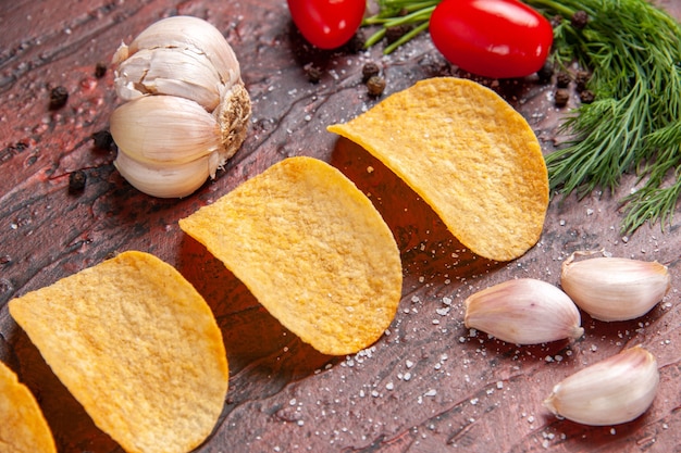 Vista cercana de deliciosos cuatro chips crujientes caseros pimiento rojo ajo tomates verdes sobre fondo oscuro imagen