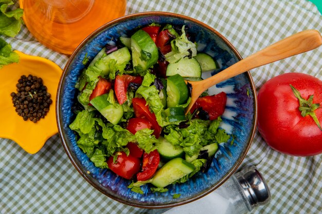 Vista cercana de ensalada de verduras con tomate pimienta negra sal mantequilla derretida