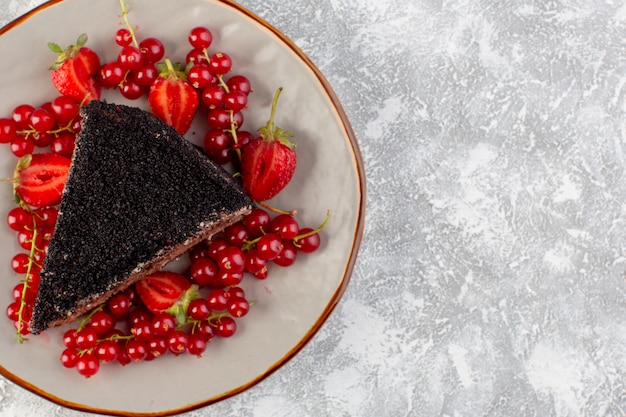 Vista cercana frontal delicioso pastel de chocolate en rodajas con crema de chocolate y arándanos rojos frescos