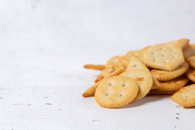 Vista cercana frontal formó galletas saladas aisladas en la superficie blanca