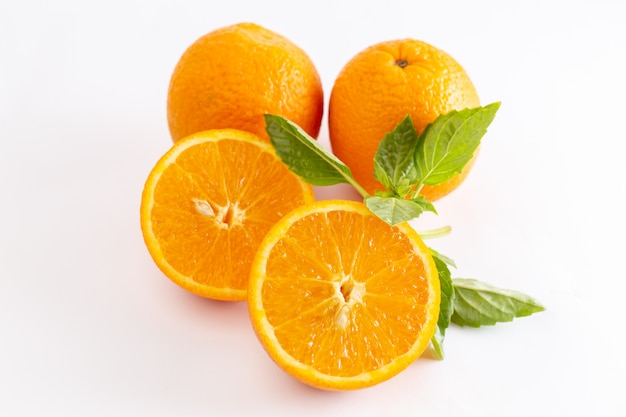 Vista cercana frontal naranjas enteras frescas jugosas y agrias en la superficie blanca