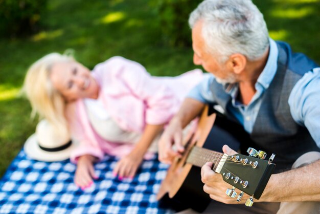 Vista cercana hombre con guitarra en el picnic