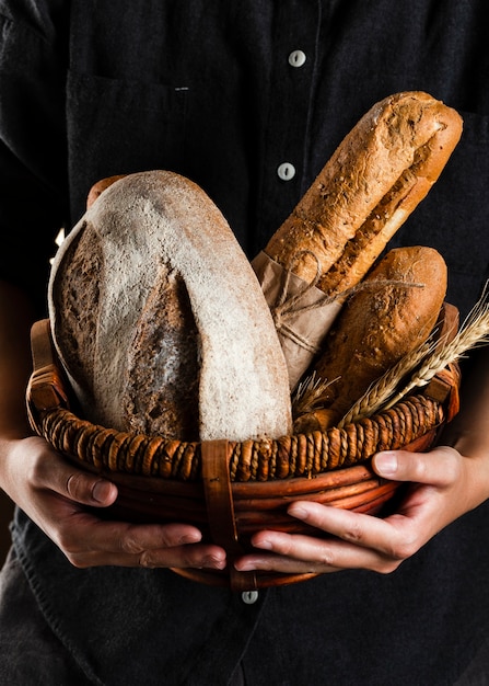Vista cercana de un hombre sosteniendo una cesta de pan