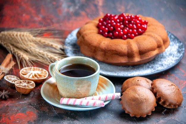 Vista cercana de lado pastel con bayas un apetitoso pastel cupcakes una taza de té dulces de anís estrellado