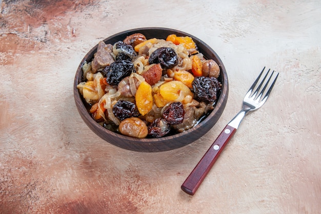 Vista cercana lateral de arroz pilaf con frutos secos en el tenedor del tazón de fuente