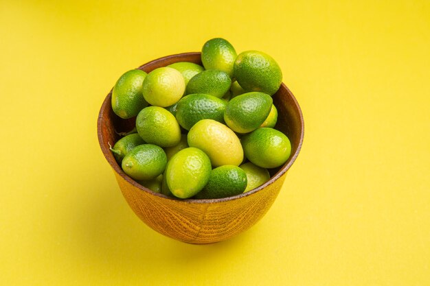 Vista cercana lateral frutas las apetitosas frutas verdes en la superficie amarilla