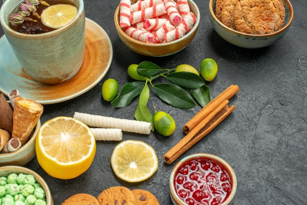 Vista cercana lateral una taza de té una taza de té de hierbas limón los apetitosos dulces galletas mermelada