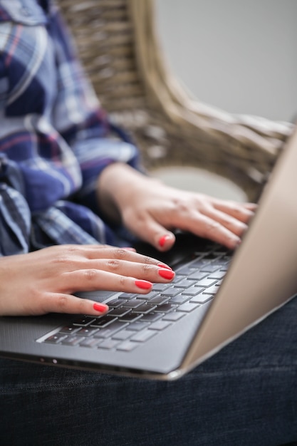 Vista cercana de manos con manicura usando computadora