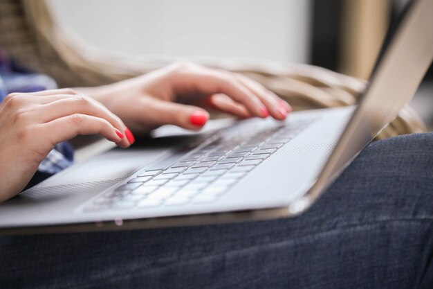 Vista cercana de manos con manicura usando computadora