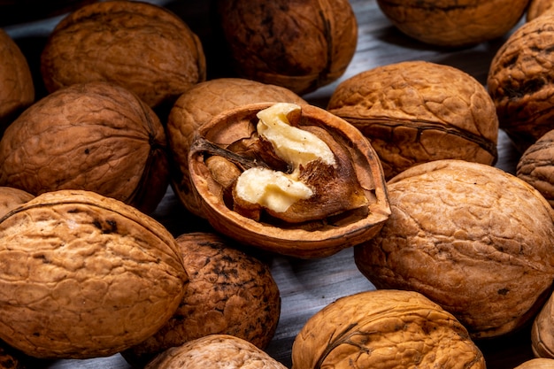 Vista cercana de nueces cerradas y rotas esparcidas sobre una madera