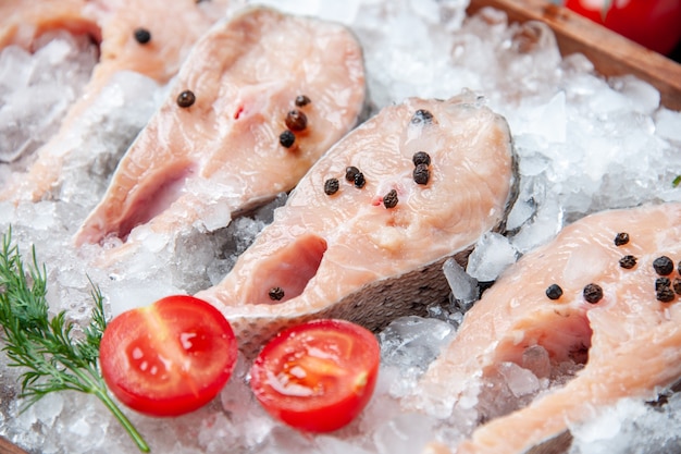 Foto gratuita vista cercana de pescado crudo en rodajas con rodajas de tomate helado