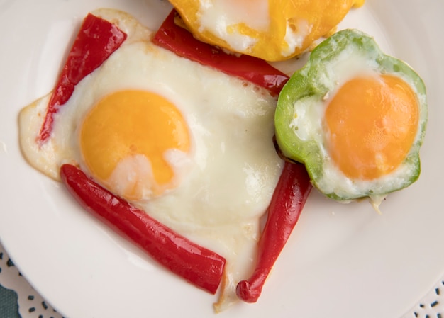 Foto gratuita vista cercana del plato de desayuno con pimiento y huevo en tapete de papel