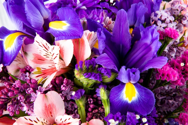 Vista cercana de un ramo de rosa y morado alstroemeria lila iris y flores de statice
