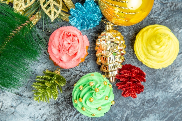 Vista cercana superior coloridos cupcakes adornos de Navidad sobre fondo gris