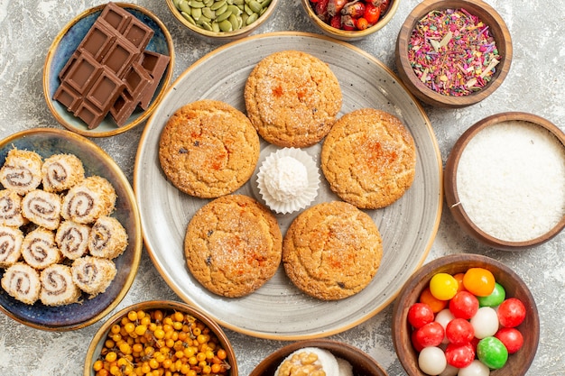 Vista cercana superior deliciosas galletas con panecillos dulces en mesa blanca galletas galleta dulce