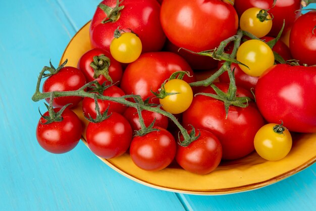 Vista cercana de tomates en un tazón sobre superficie azul