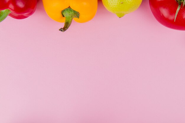 Vista cercana de verduras como tomate pimiento con limón sobre fondo morado con espacio de copia