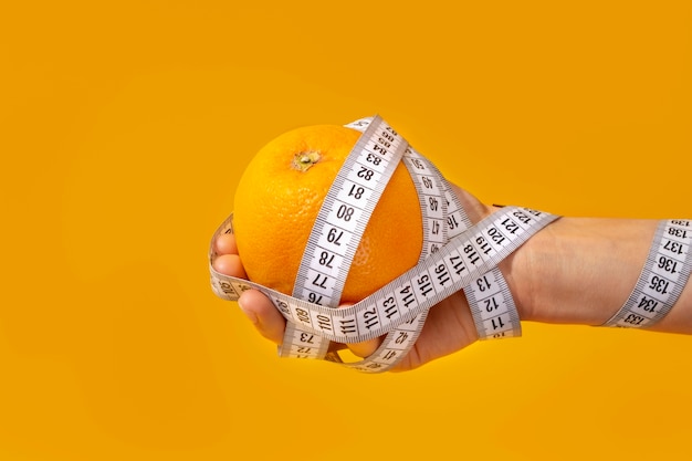 Foto gratuita vista de cinta métrica con fruta naranja