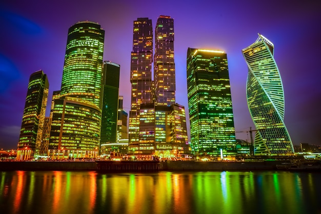 Vista de una ciudad con rascacielos iluminados por la noche