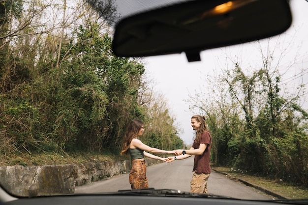 Foto gratuita vista desde un coche de pareja joven en medio de la calle