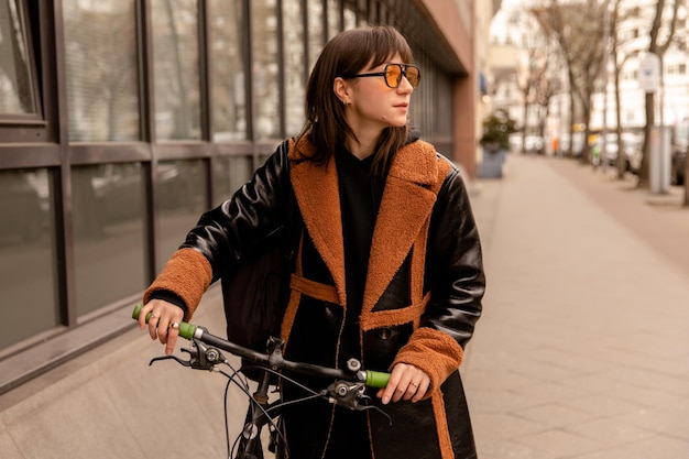 Vista completa de mujer con gafas de sol amarillas con bicicleta