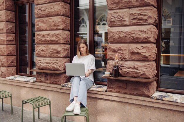 Vista completa de una mujer hermosa en un café trabajando en una laptop