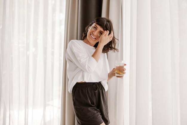 Vista completa de la mujer con parches verdes en casa sonriendo a la cámara