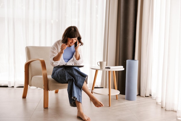 Vista completa de la mujer sentada en casa