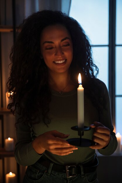 Vista delantera de una mujer sonriente con una vela