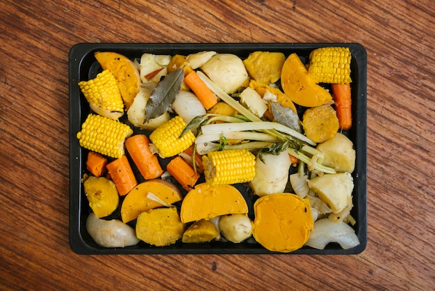 Foto gratuita vista elevada de alimentos frescos en bandeja sobre fondo de madera