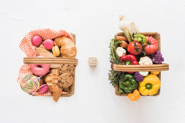 Vista elevada de alimentos horneados versus verduras frescas en el fondo blanco