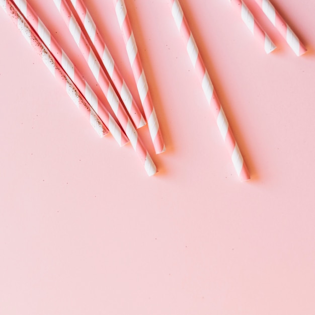 Foto gratuita vista elevada de bastones de caramelo sobre fondo rosa