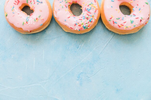 La vista elevada de los buñuelos sabrosos adornados con asperja en fondo azul