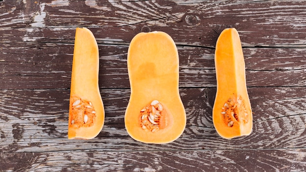 Una vista elevada de la calabaza a la mitad en la mesa de madera