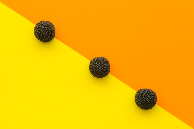 Foto gratuita vista elevada de caramelos blackberry en una fila en colores de fondo