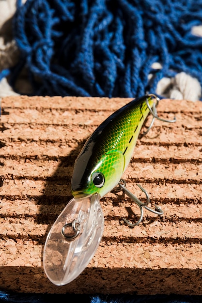 Una vista elevada de cebo de pesca verde en tablero de corcho