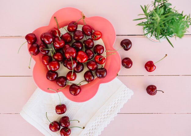 Vista elevada de cerezas rojas en plato con forma de flor