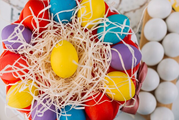 Una vista elevada de coloridos huevos de Pascua en papel triturado