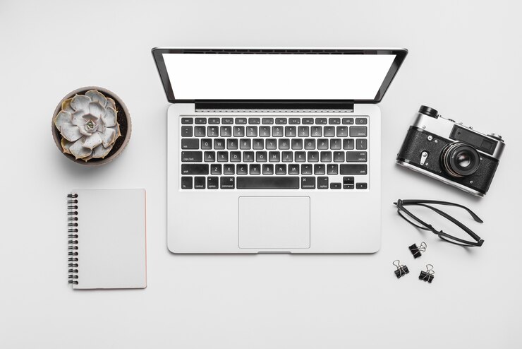 Foto gratuito vista elevada de una computadora portátil y una cámara retro aisladas sobre fondo blanco