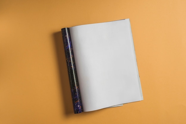 Vista elevada del cuaderno en blanco sobre fondo vibrante
