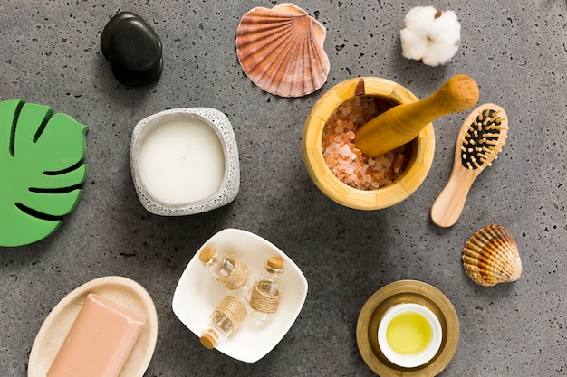 Vista elevada de diversos productos para el cuidado de la belleza y conchas de mar